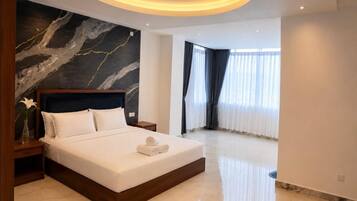 A modern bedroom with a large bed, a marble wall, and a ceiling light fixture.