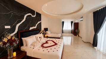 A hotel room with two beds, a marble floor, a large mirror, and a modern ceiling design.