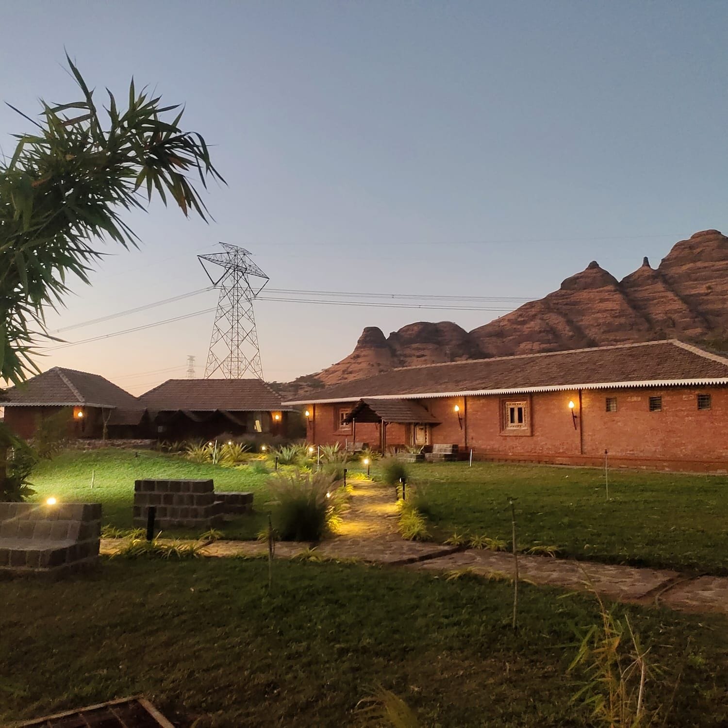 A brick building with a flat roof, surrounded by a well-maintained lawn and a few trees.
