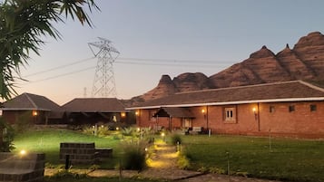 A brick building with a flat roof, surrounded by a well-maintained lawn and a few trees.
