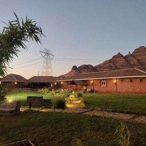 A brick building with a flat roof, surrounded by a well-maintained lawn and a few trees.