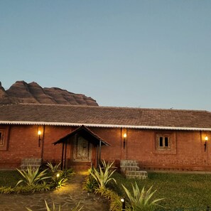 A rustic building with a tiled roof, a central entrance, and a small porch area.