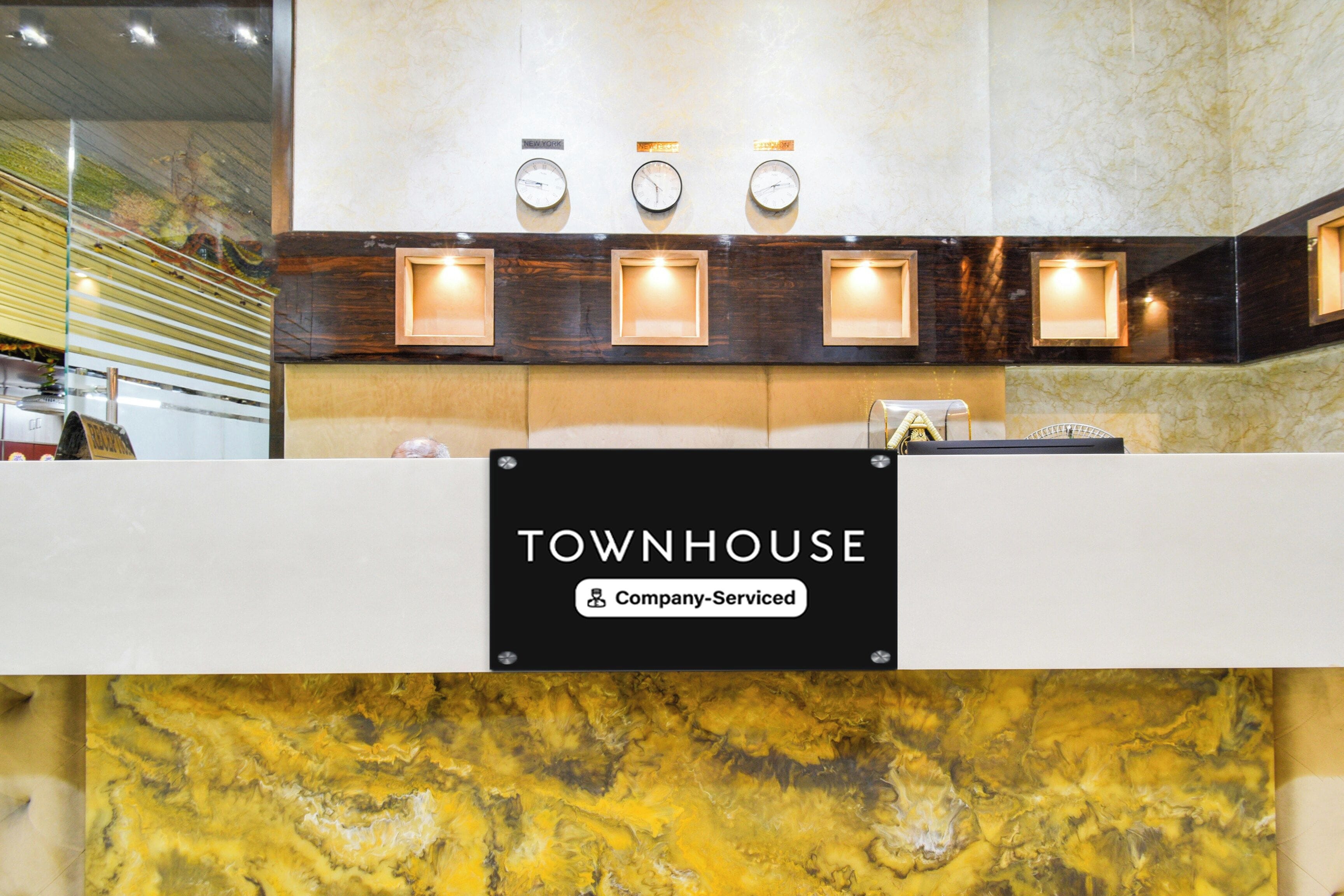 A reception desk with a sign reading 'TOWNHOUSE & Company-Serviced'.