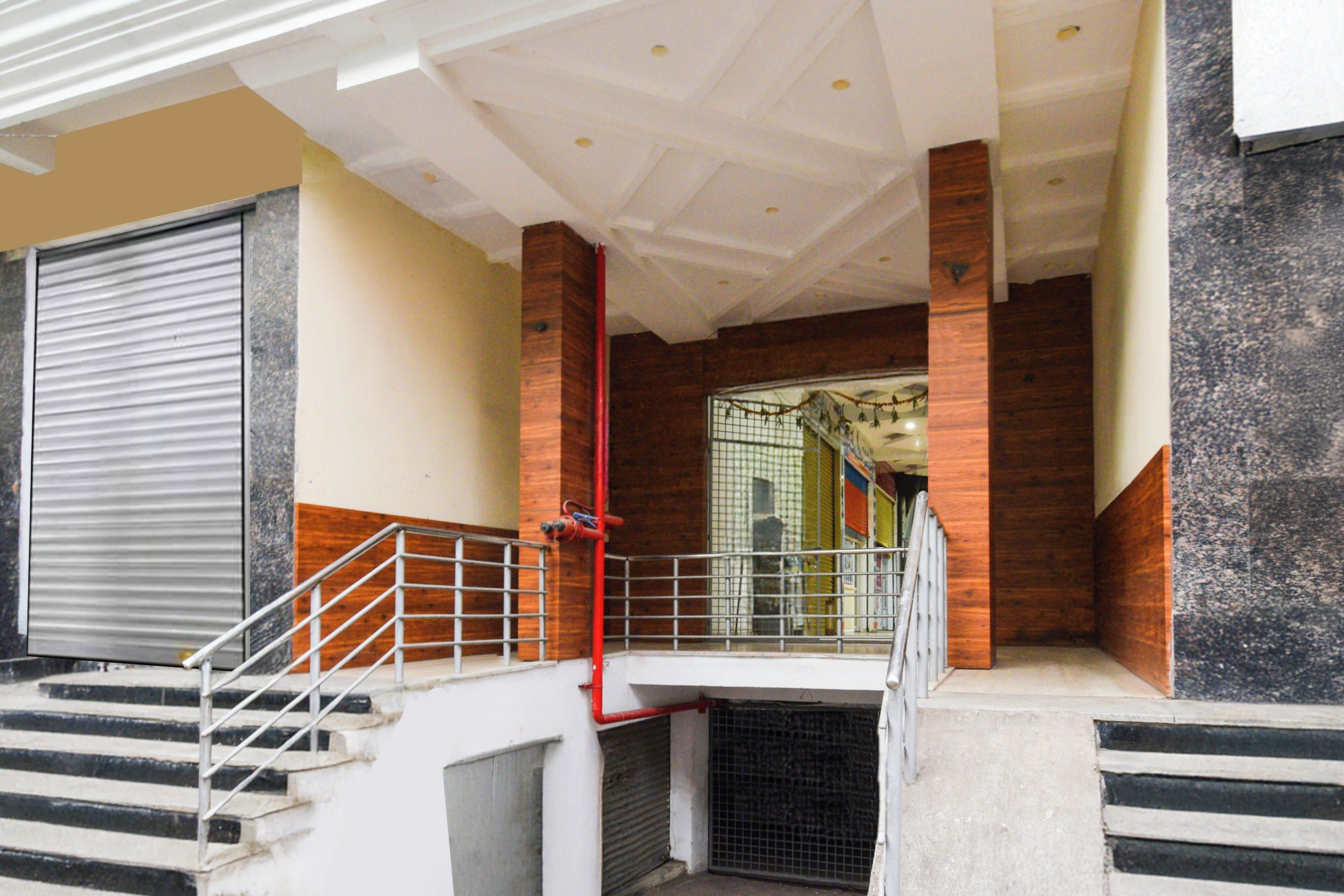 A staircase with metal railings leading to a landing with a closed shutter door.