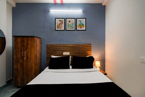 Un dormitorio con cama, armario y tres cuadros en la pared.