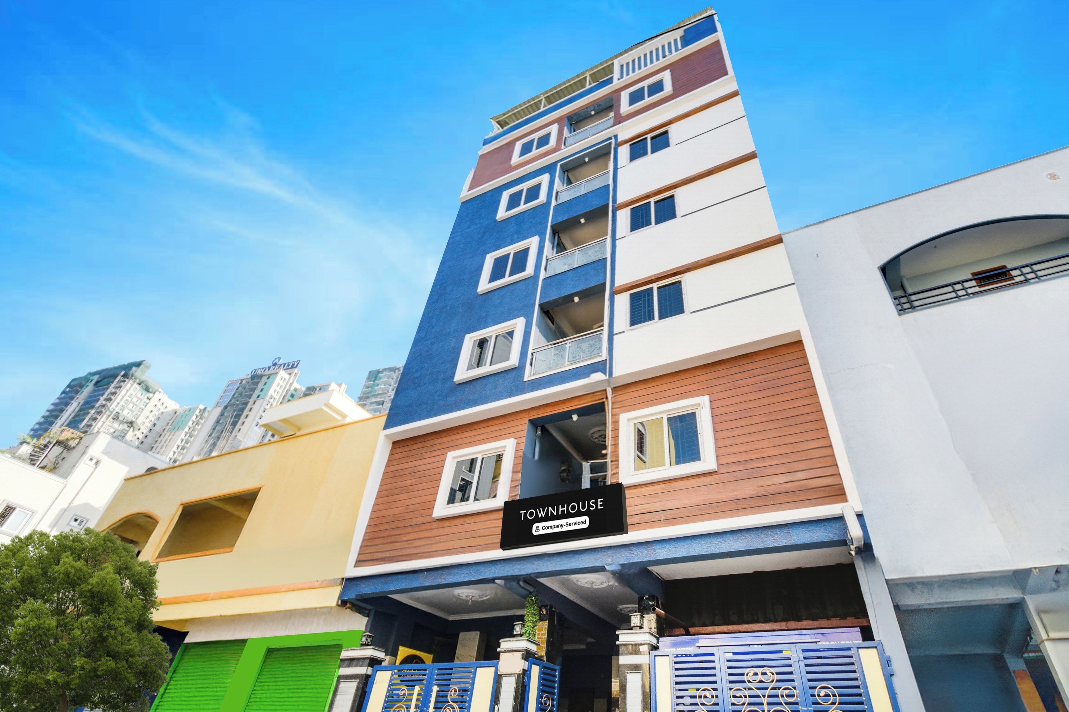 A multi-story building with a sign indicating it is a company-serviced townhouse.