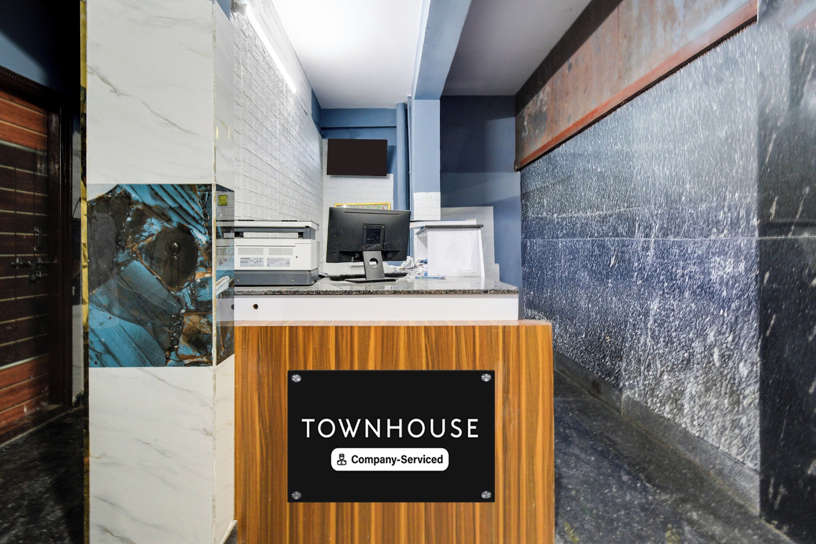 Una mesa de recepción con un letrero que dice 'TOWNHOUSE Company Serviced'.