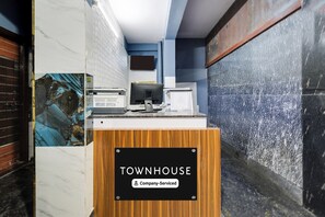 A reception desk with a sign that reads 'TOWNHOUSE Company Serviced'. - Super Townhouse Hitech City (Hyderabad)
