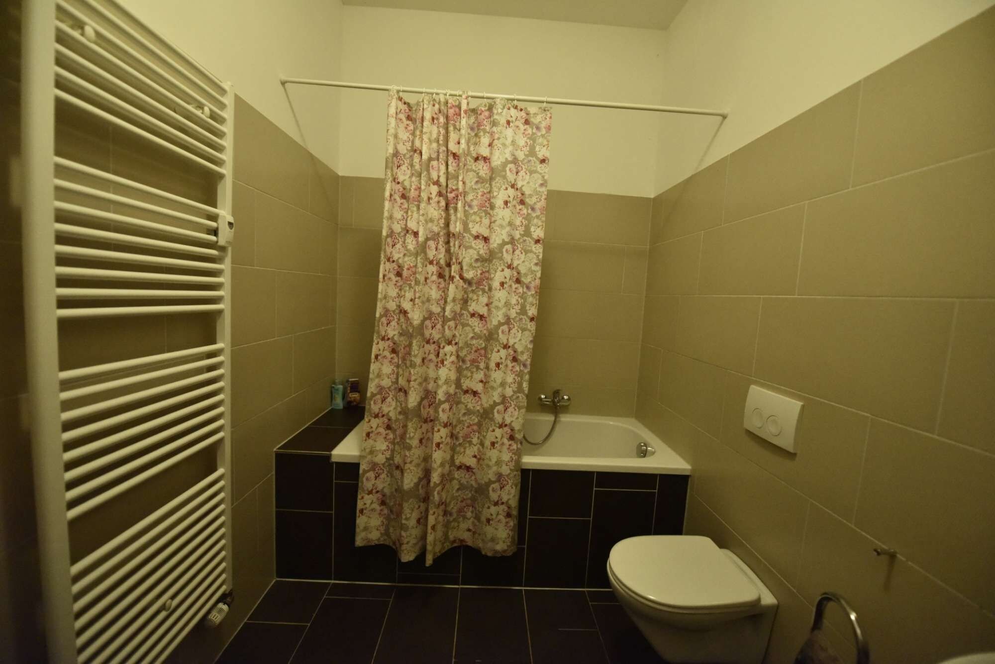 Ein Badezimmer mit einer Badewanne, Toilette und einer Duschvorhang.