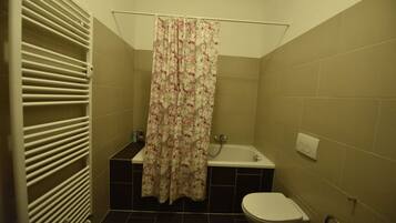 Ein Badezimmer mit einer Badewanne, Toilette und einer Duschvorhang.