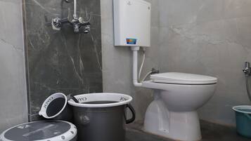 Une salle de bain équipée de toilettes, d’une douche et d’un chauffe-eau.