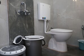 A bathroom with a toilet, a shower, and a water heater.