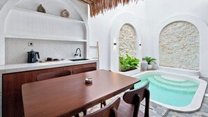 A modern kitchen with a dining area and a small pool. - Mataram Royal Villa Jogja (Kota Yogyakarta)