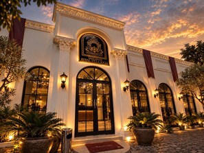 A hotel entrance with a sign reading 'Mataram Royal Villa Joya,' featuring arched windows and a welcoming entrance.