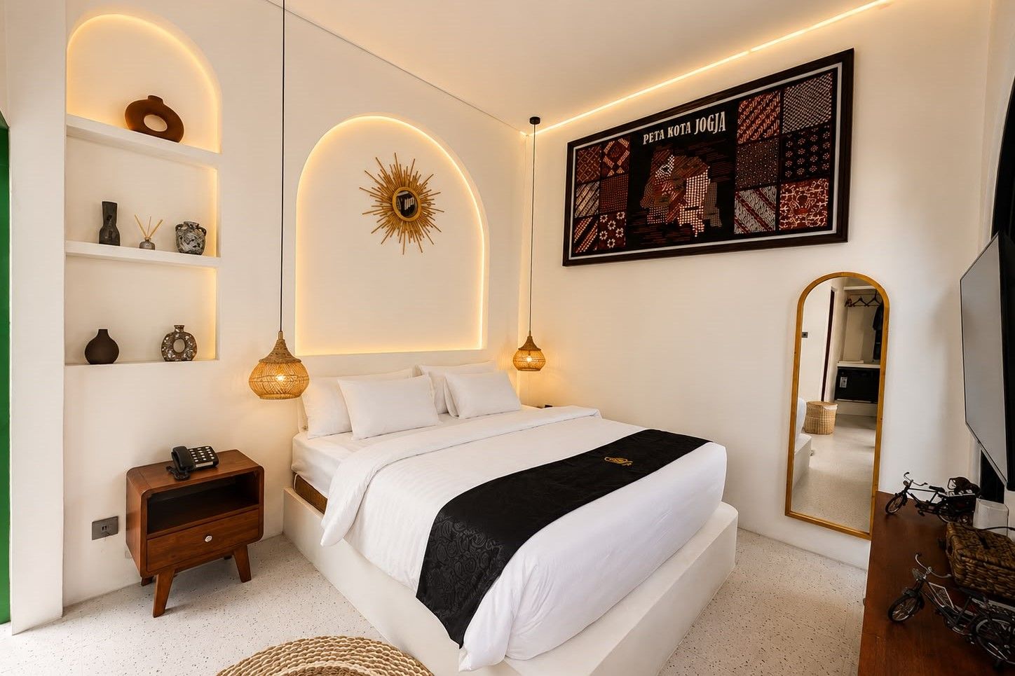 Un dormitorio moderno con cama, lámparas de noche, una obra de arte en la pared y un espejo.