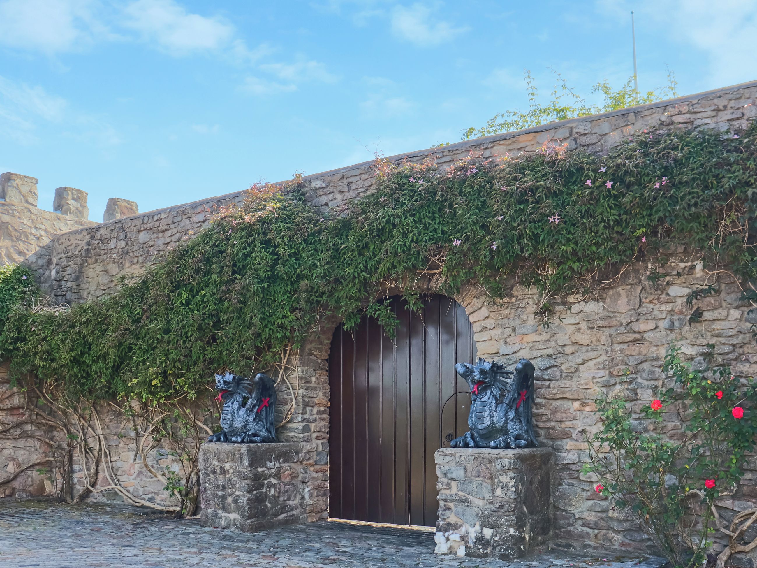 Un edificio de piedra con una puerta de madera y dos estatuas a cada lado.