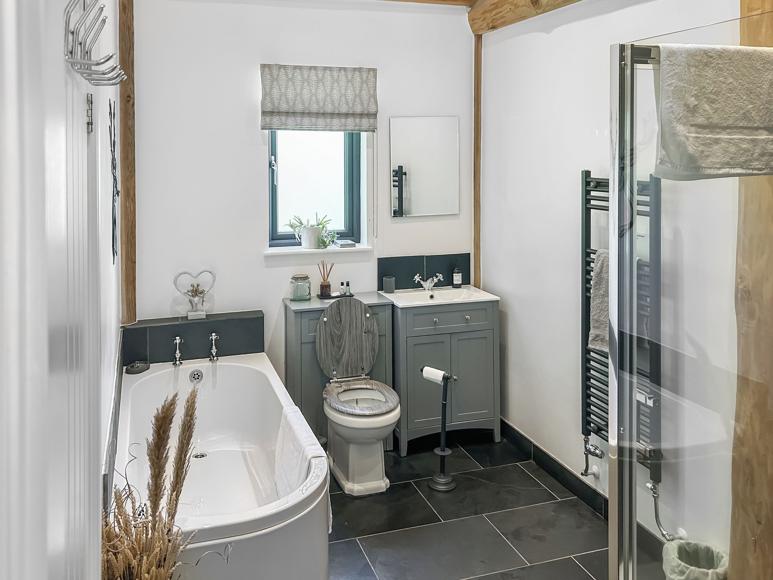 A bathroom with a bathtub, toilet, vanity, and a shower area.