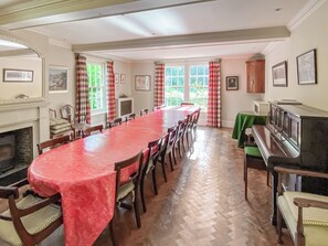 A dining room with a long table, chairs, a fireplace, and a piano. - Ultimate Country House (Boston)