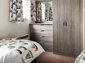 A bedroom with a bed, a wardrobe, and curtains with a nautical theme. - The Kingfisher 2 - UKC9970 (Christchurch)