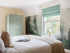 A bedroom with a bed, a wardrobe, a window with a view, and a radiator. - Woodside Cottage - UKC9989 (Harewood, near Leeds)