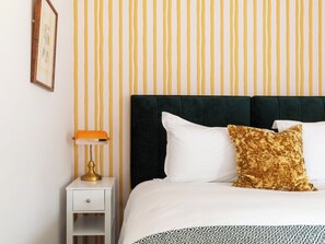 A neatly made bed with white and patterned bedding, a dark headboard, and a single decorative pillow. - Woodside Lodge - UKC9988 (Harewood, near Leeds)