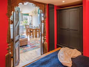 Une chambre avec un lit, une armoire et une vue sur l’espace repas.