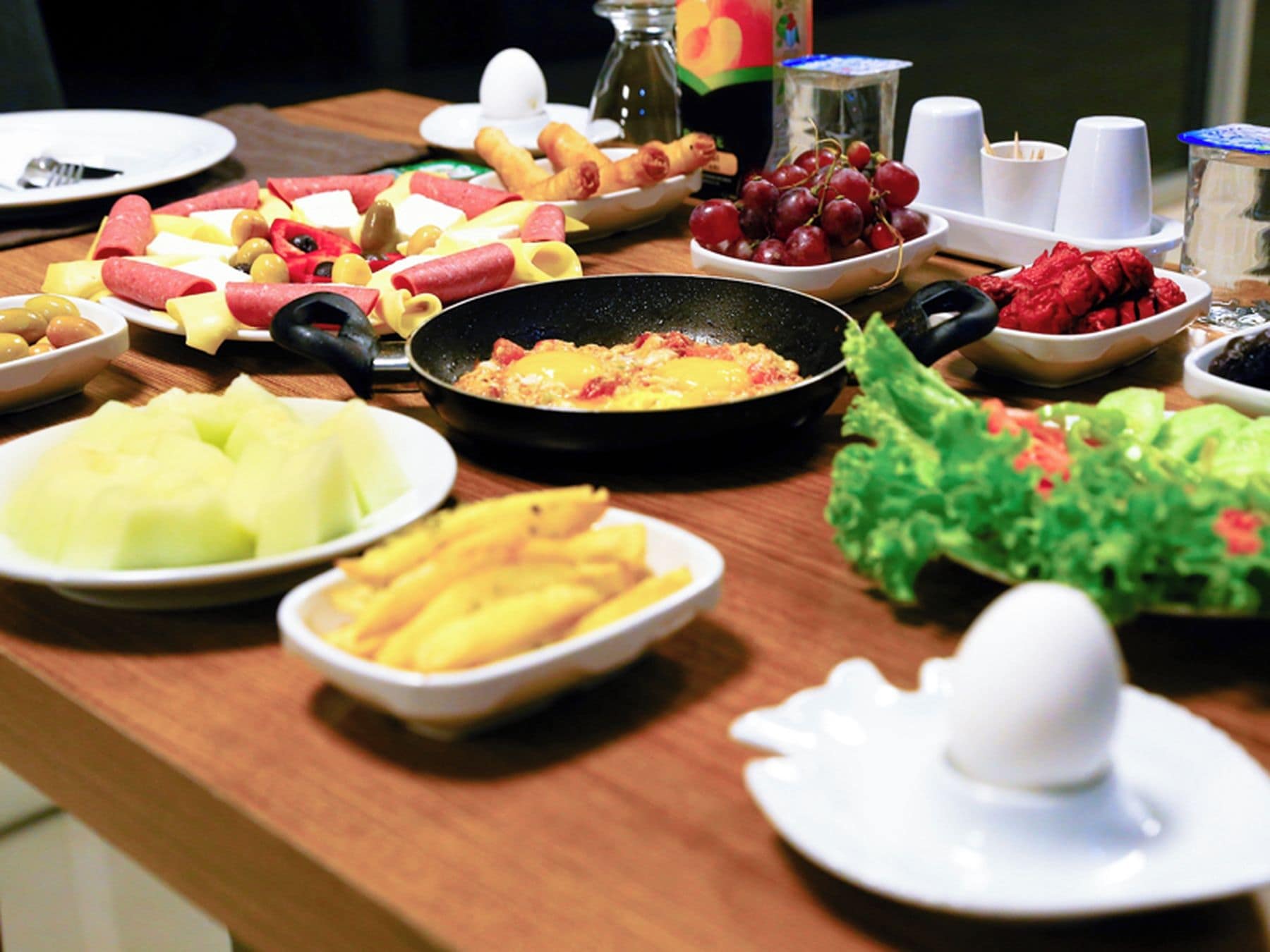 A breakfast buffet with various fruits, cheeses, and meats.