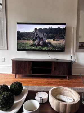Ein Fernseher an der Wand, darunter eine Holz-Unterhaltungseinrichtung.