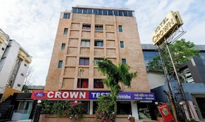 A hotel named 'Crown Test' with a signboard, a flag, and a storefront for 'Pizza - Pasta' visible. - Hotel Crown Ahmedabad (Ahmedabad)