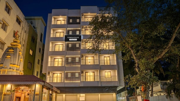 A multi-story building with a sign reading 'TOWNHOUSE' and a gated entrance. - Super Townhouse Hitech City Near Yashoda (Hyderabad)