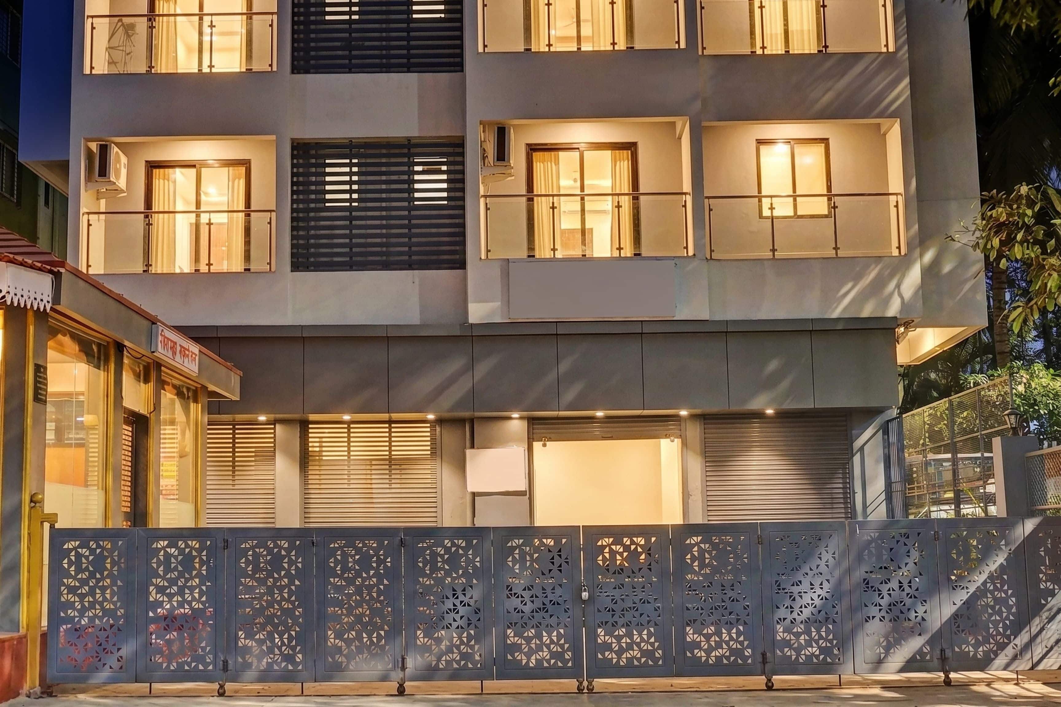 A multi-story building with balconies, windows, and a decorative metal fence.