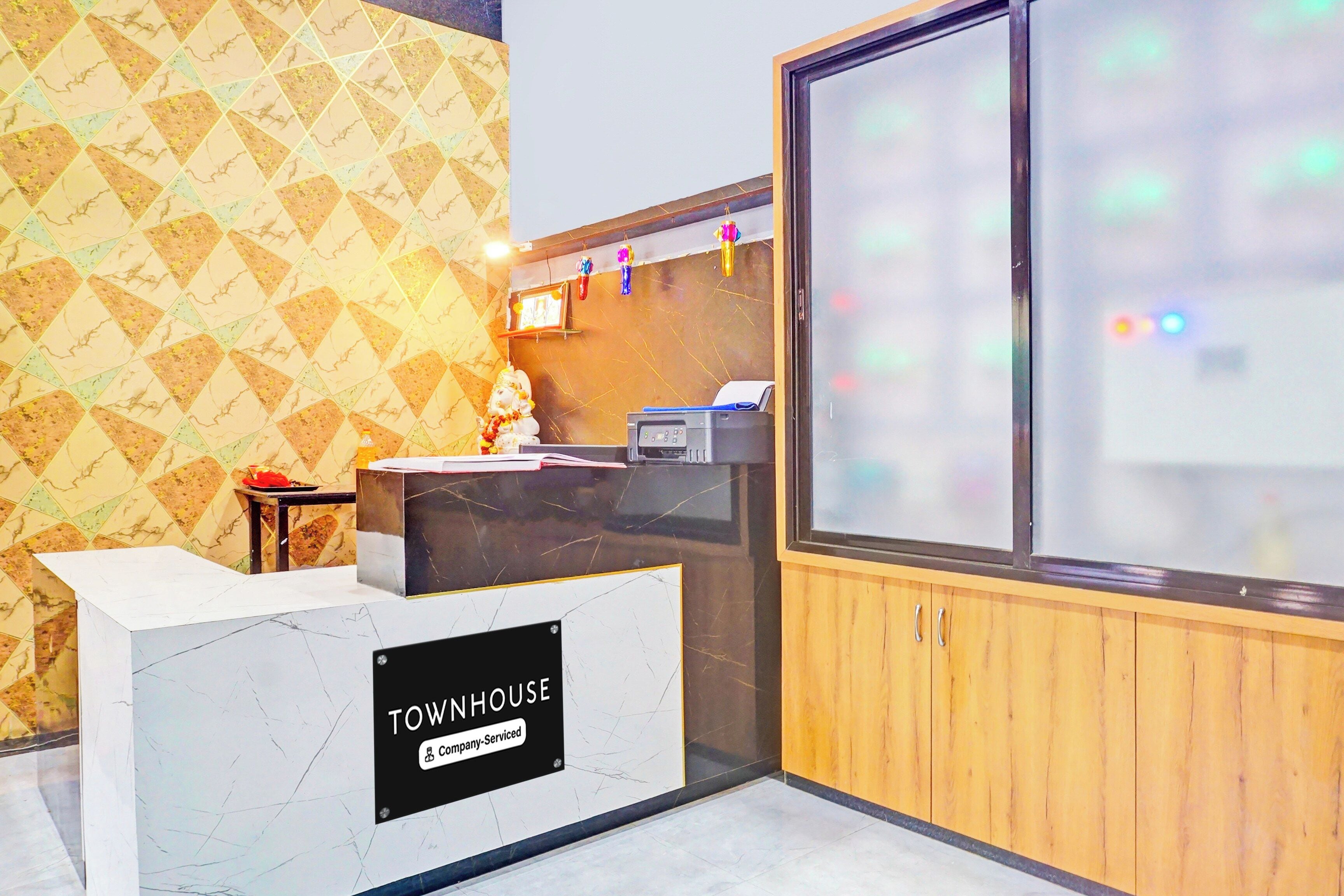 A reception desk with a marble top and a sign that reads 'TOWNHOUSE company-serviced.'