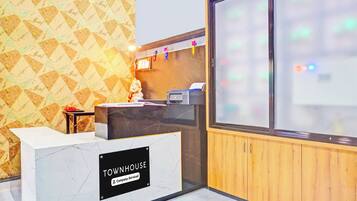 A reception desk with a marble top and a sign that reads 'TOWNHOUSE company-serviced.'
