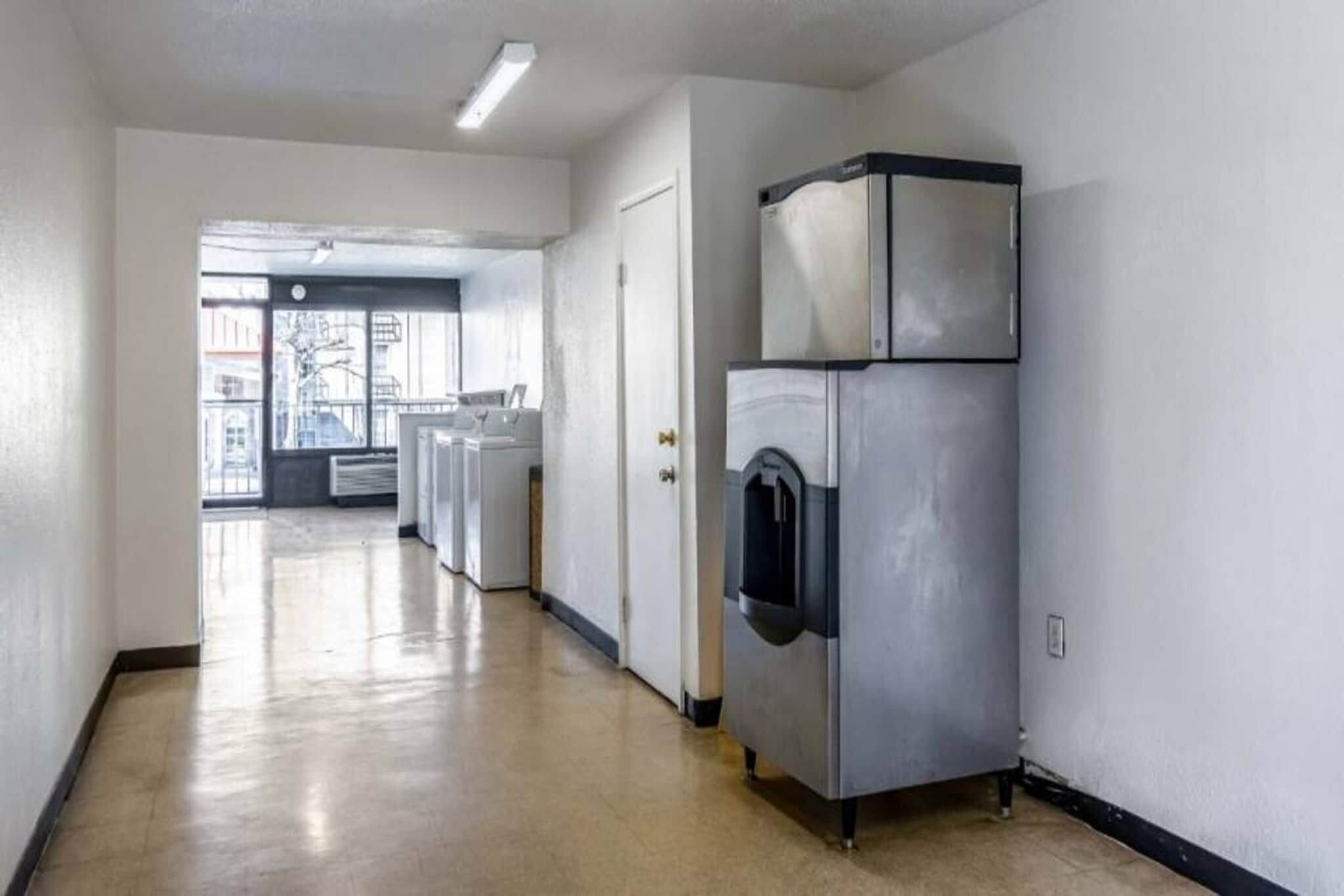 A hallway with a laundry machine and a door.