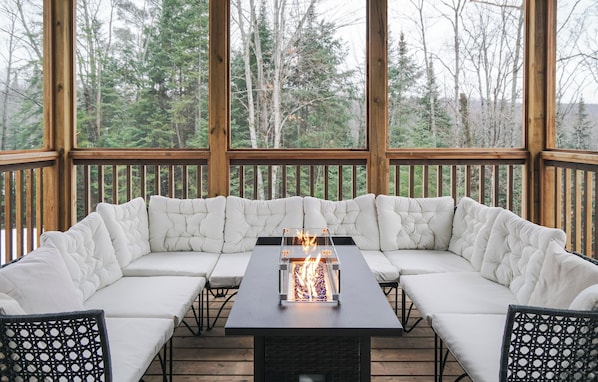 A covered outdoor seating area with a fire feature. - Beautiful Muskoka Cottage with Games, BBQ & Views (Huntsville)