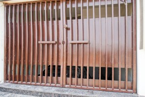 A large metal gate with vertical bars and two handles. - Super OYO Townhouse Oak Ratanpur Panki (Kanpur)