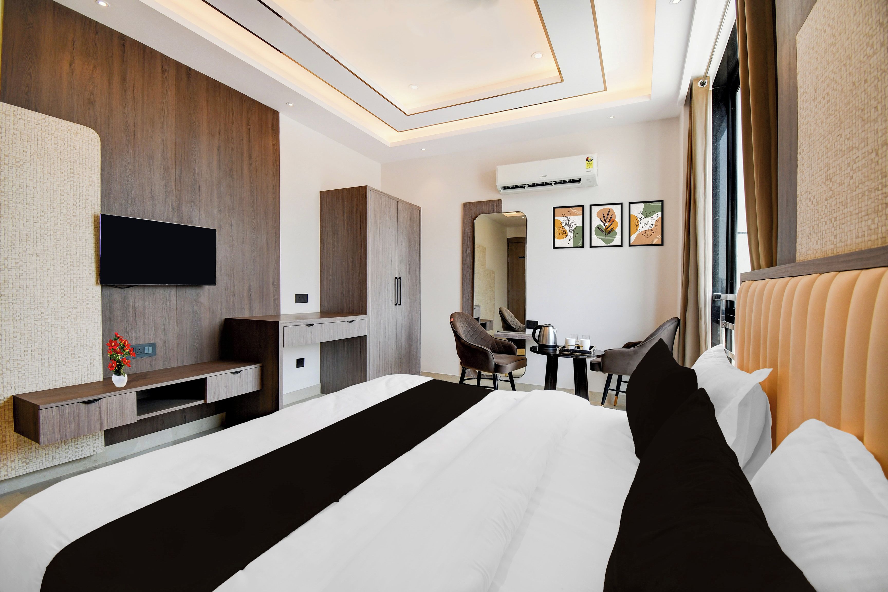 Una habitación de hotel moderna con una cama grande, un escritorio, una silla y un televisor.