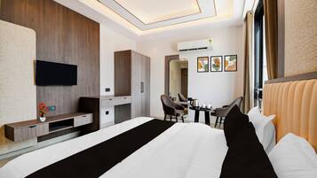 Una habitación de hotel moderna con una cama grande, un escritorio, una silla y un televisor.