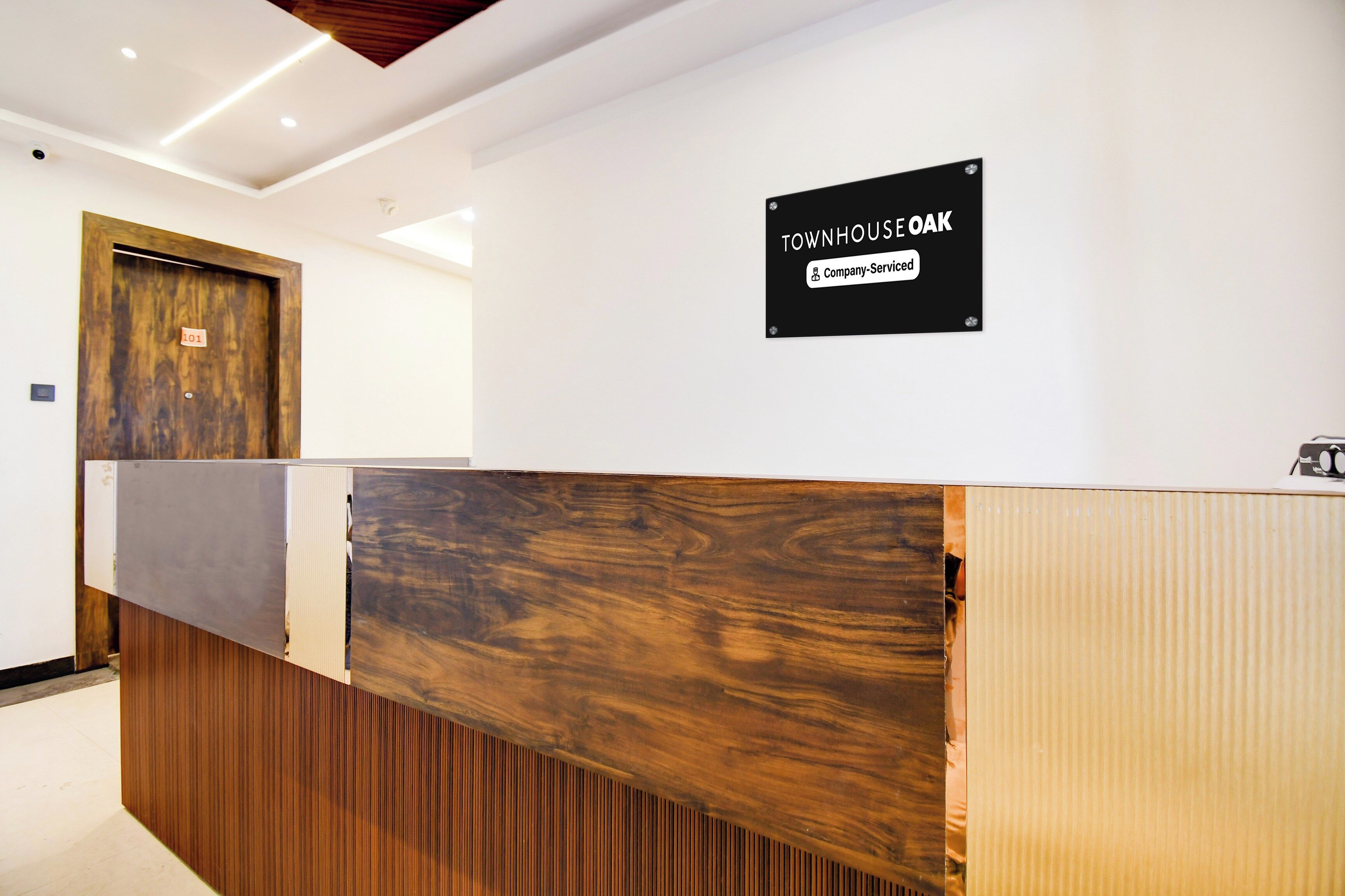 Un mostrador de recepción con detalles de madera y un cartel encima.