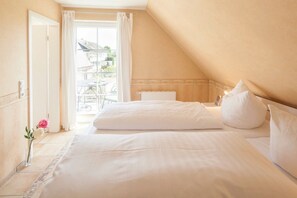 Ein Schlafzimmer mit einem großen Bett, einem Fenster mit Vorhängen und Blick nach draußen.