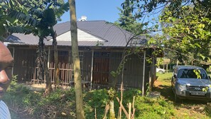 A residential property with a metal roof, a wooden fence, and a parked car. - Serene 3-bedroom building in charming Kakamega County perfect for relaxing (Kakamega County)