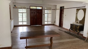 A room with a wooden table, a large mirror, and a wardrobe. - Serene 3-bedroom building in charming Kakamega County perfect for relaxing (Kakamega County)