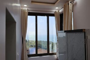 A room with a large window, a radiator, and a door.