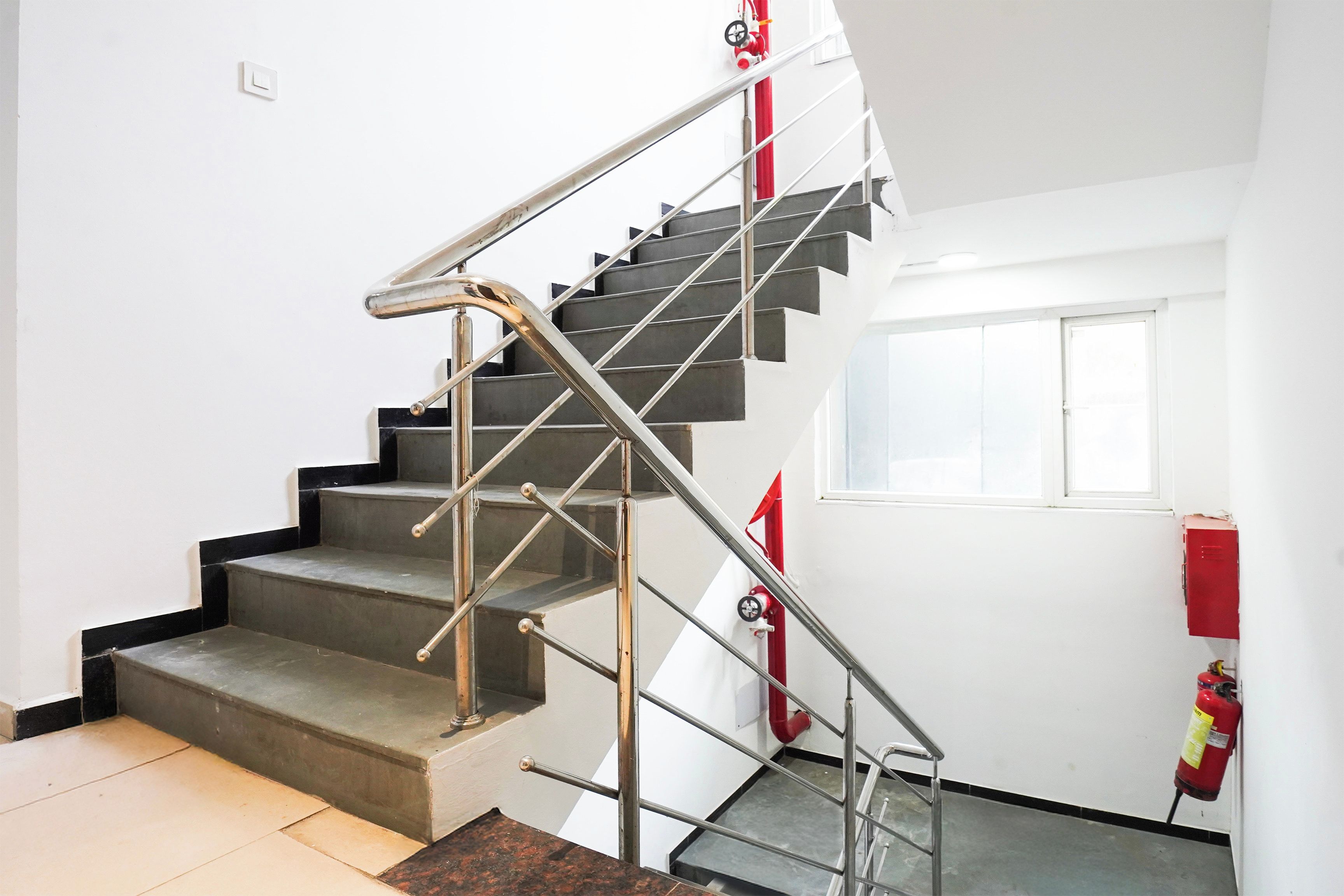 Eine Treppe mit Metallgeländern und einem an der Wand befestigten Feuerlöscher.