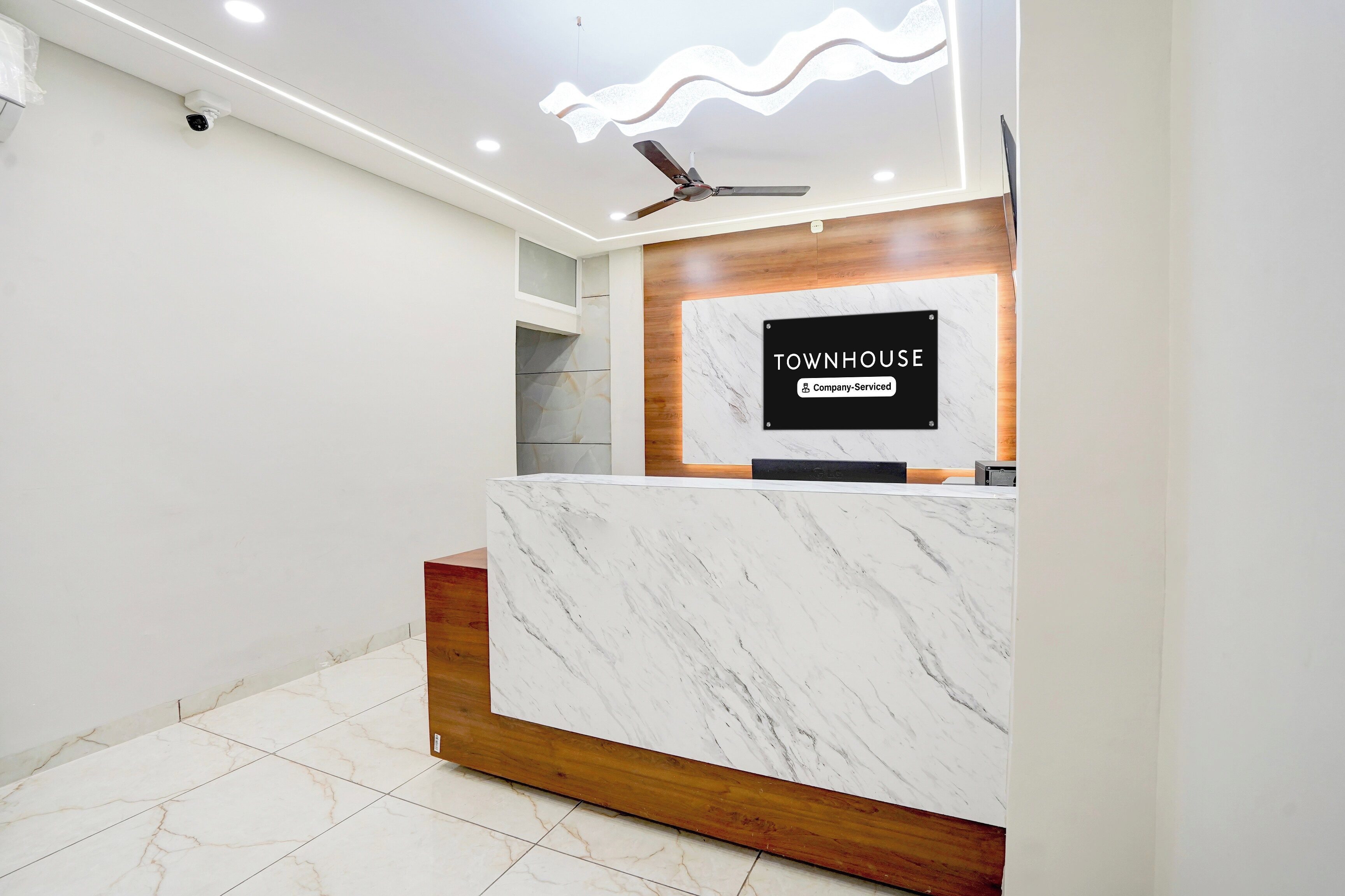 Un mostrador de recepción con encimera de mármol y un cartel que dice 'TOWNHOUSE Company-Serviced'.