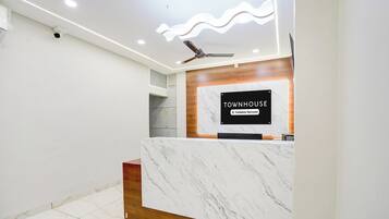 Un mostrador de recepción con encimera de mármol y un cartel que dice 'TOWNHOUSE Company-Serviced'.