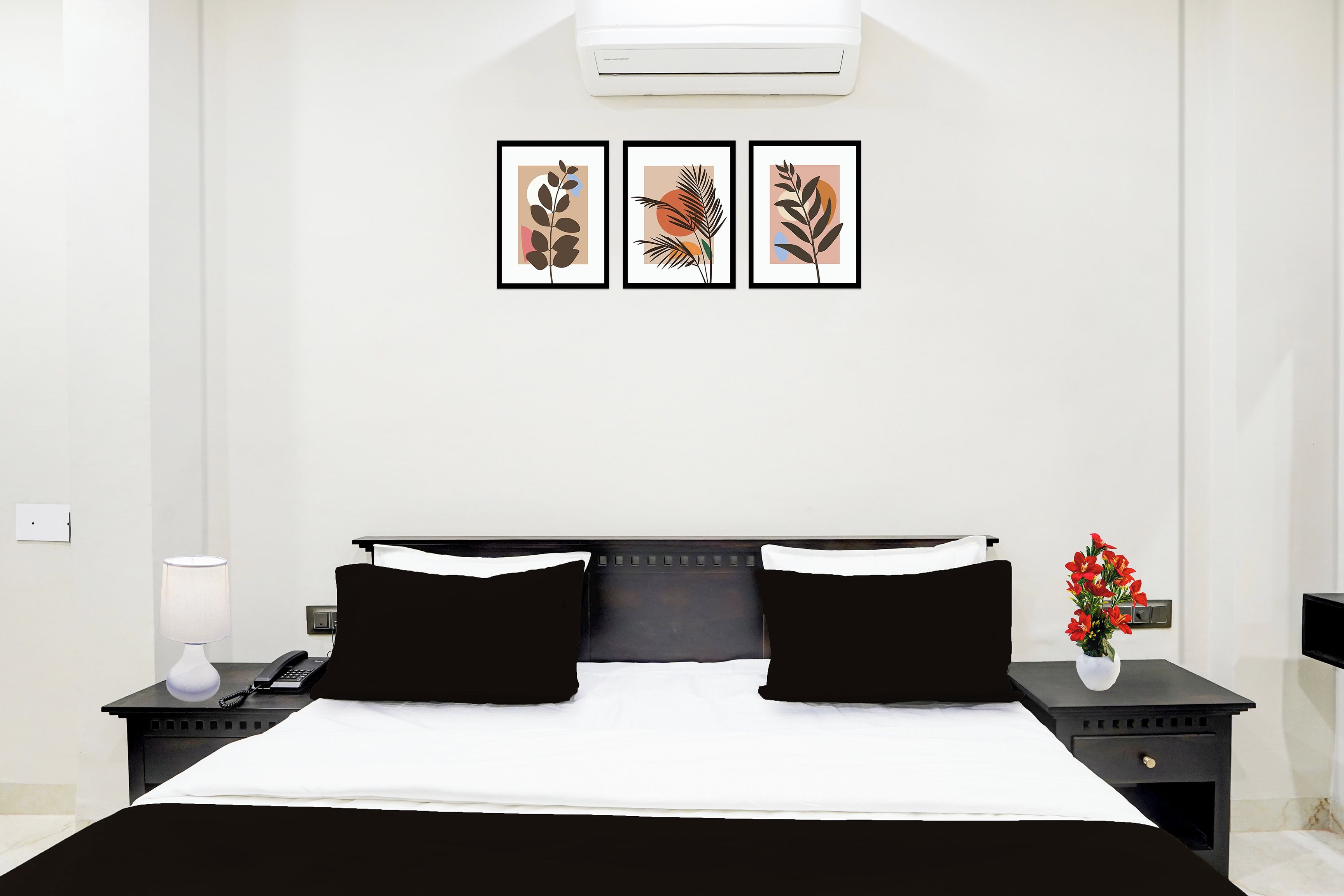 Una habitación de hotel con cama, mesitas de noche, lámpara, teléfono y aire acondicionado instalado en la pared.