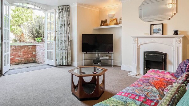 A living room with a television, fireplace, and a view of the outdoors. - 1 bedroom accommodation in Whitby (Whitby)