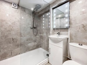 Un baño moderno con ducha, inodoro y lavabo.