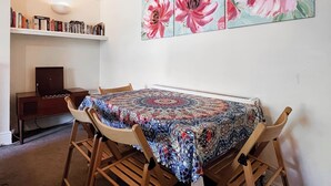 A dining area with a table set for four, surrounded by wooden chairs. - 1 bedroom accommodation in Whitby (Whitby)